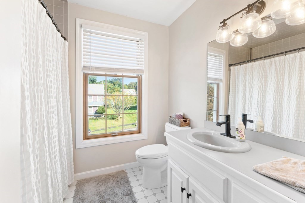 9 Bailin Drive Worcester, MA 01604 - Photo 22 of 30 a bathroom with a granite countertop sink a large mirror and a window