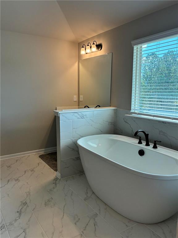 161 Donovan Avenue Locust Grove, GA 30248 - Photo 33 of 42 a bathroom with a bathtub and a window
