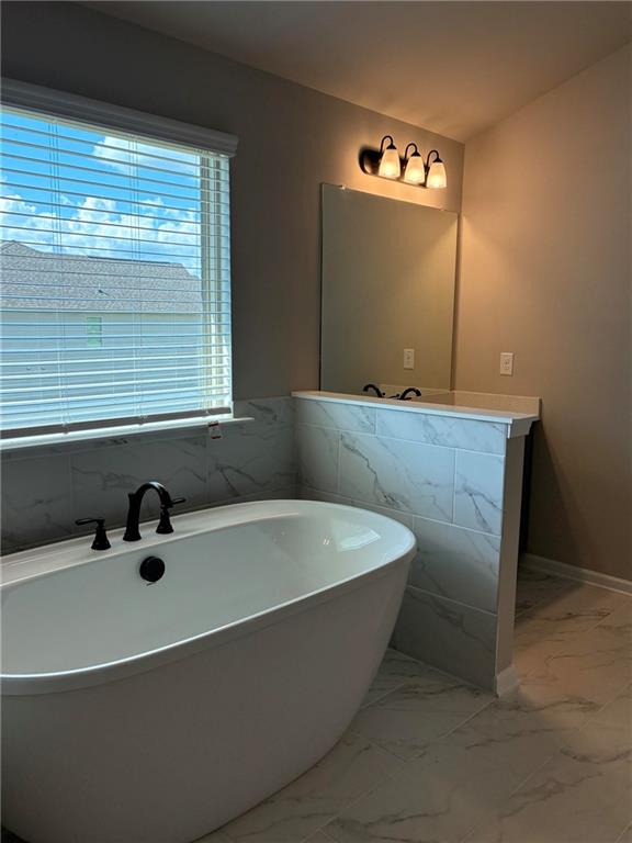 161 Donovan Avenue Locust Grove, GA 30248 - Photo 34 of 42 a bathroom with a tub a sink and a window