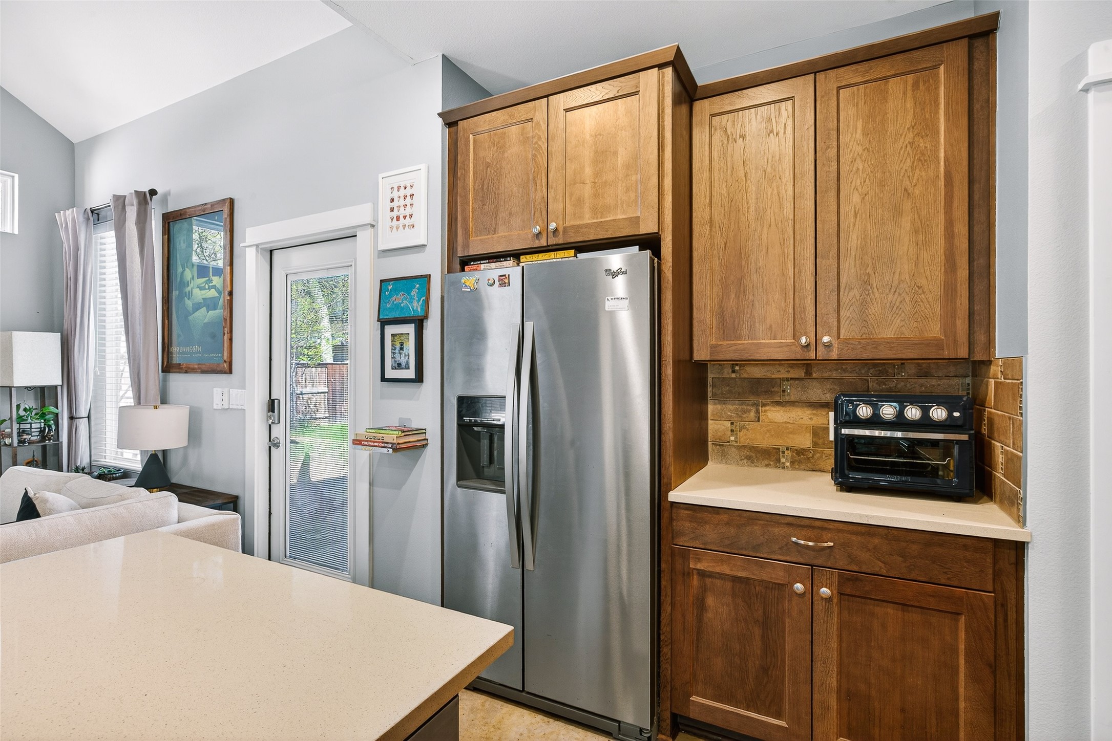 4917 Sunset Trail, Unit A Austin, TX 78745 - Photo 35 of 36 Kitchen featuring stainless steel fridge, decorative backsplash, lofted ceiling, open floor plan, and wood finish cabinetry