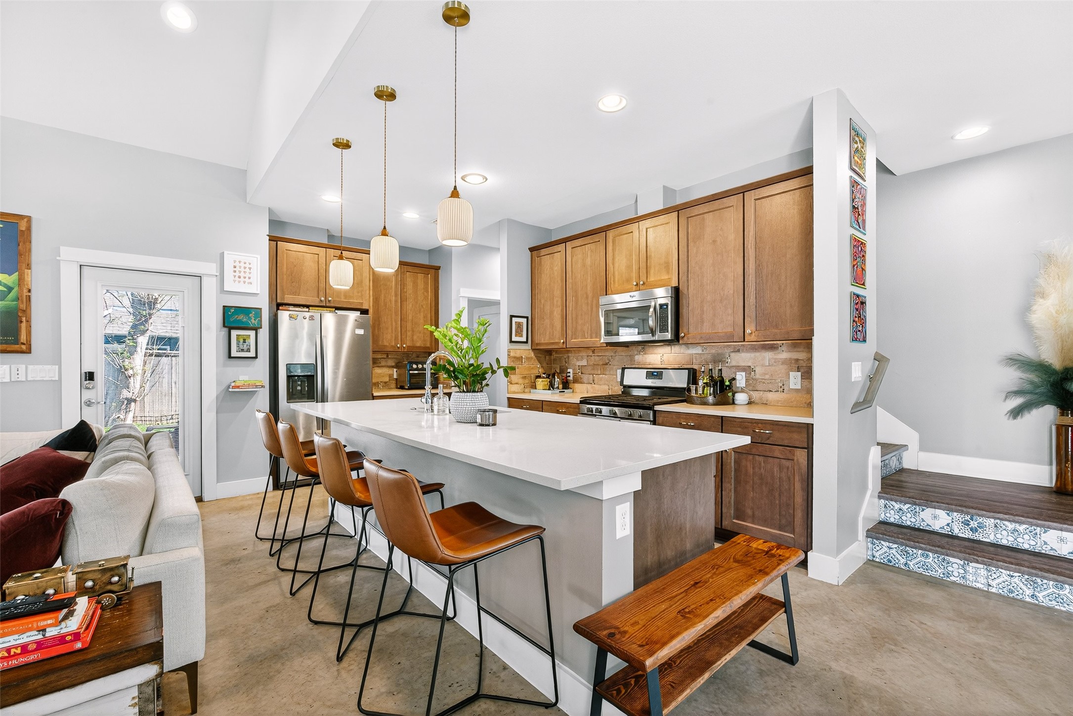 4917 Sunset Trail, Unit A Austin, TX 78745 - Photo 9 of 36 Kitchen with a kitchen bar, a center island with sink, wood finish cabinetry, stainless steel appliances, and pendant lighting