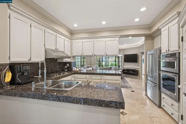 a kitchen with sink a counter top space cabinets and stainless steel appliances