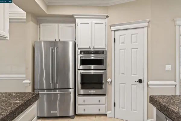 a view of kitchen with refrigerator and cabinet