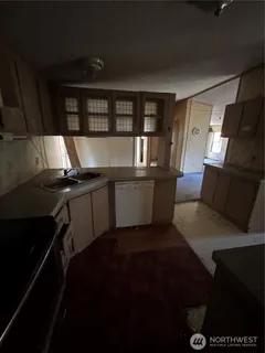 a living room with stainless steel appliances a fireplace