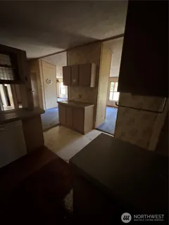 a living room with stainless steel appliances wooden floor and a fireplace