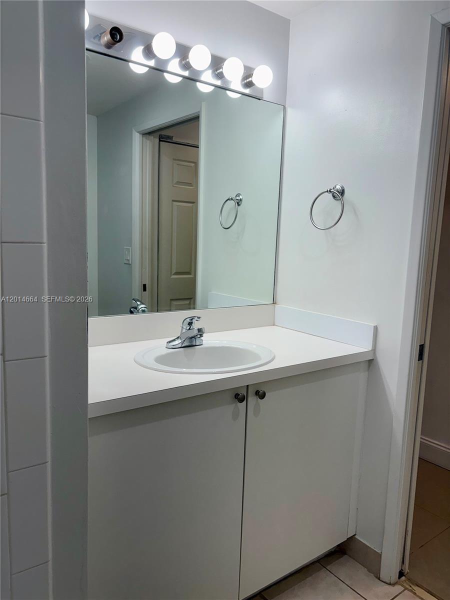 8030 North Nob Hill Road, Unit 105 Tamarac, FL 33321 - Photo 14 of 22 a bathroom with a sink and a mirror
