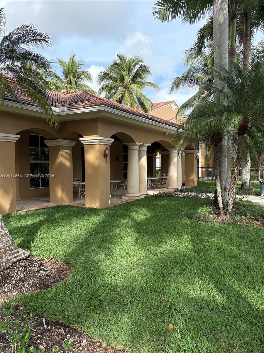 8030 North Nob Hill Road, Unit 105 Tamarac, FL 33321 - Photo 20 of 22 a front view of house with yard and outdoor seating