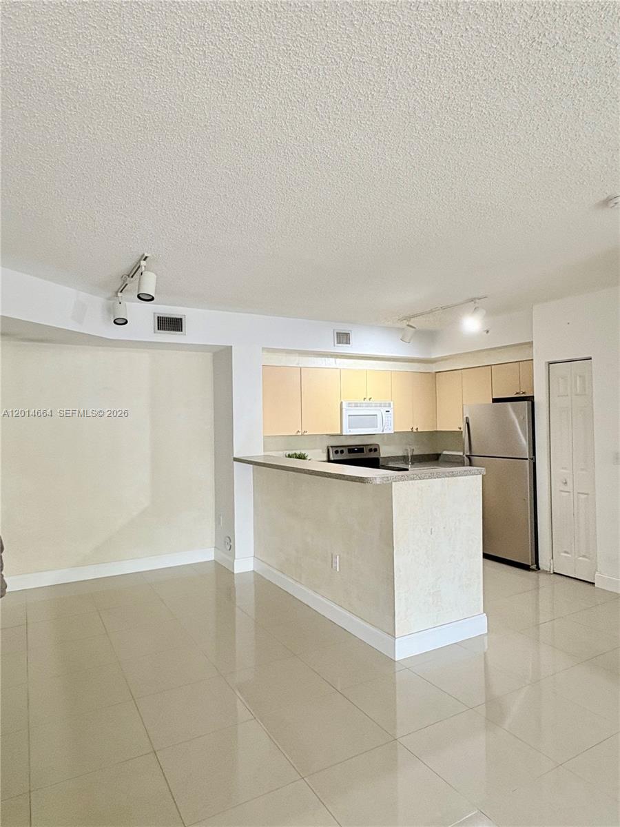 8030 North Nob Hill Road, Unit 105 Tamarac, FL 33321 - Photo 2 of 22 a kitchen with granite countertop a sink and white cabinets