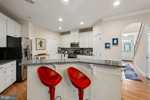 a kitchen with stainless steel appliances granite countertop a stove a sink and a refrigerator