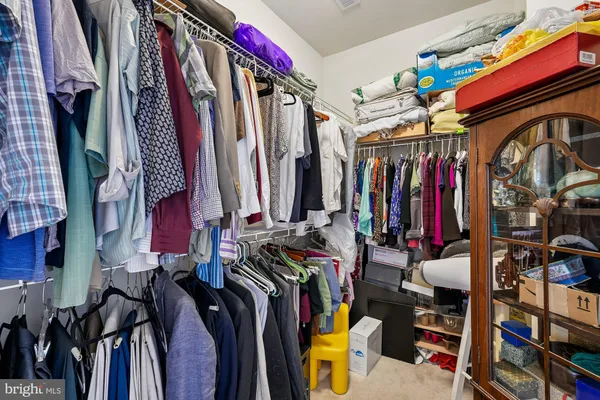 an empty room with closet and a chandelier fan