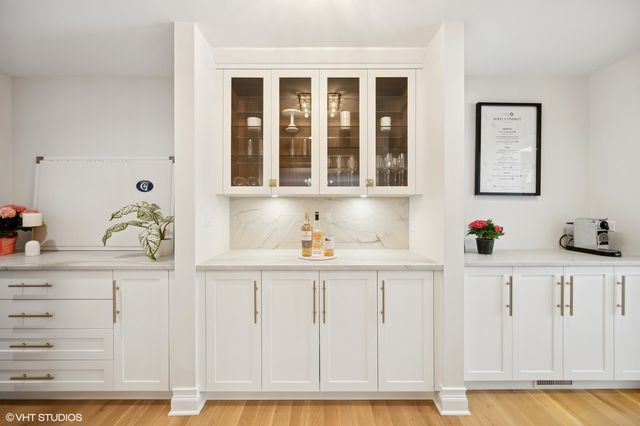 a kitchen with granite countertop white cabinets and sink