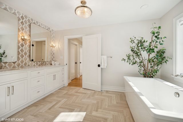 a spacious bathroom with a tub sink and mirror