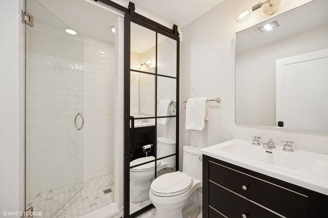 a bathroom with a sink a toilet and shower