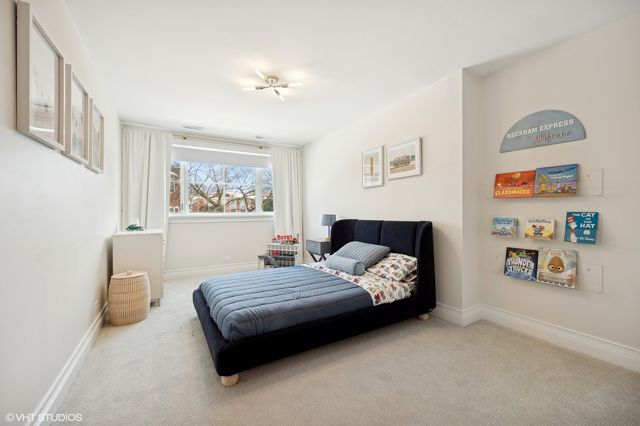 a bedroom with a bed lamp and paintings on the wall