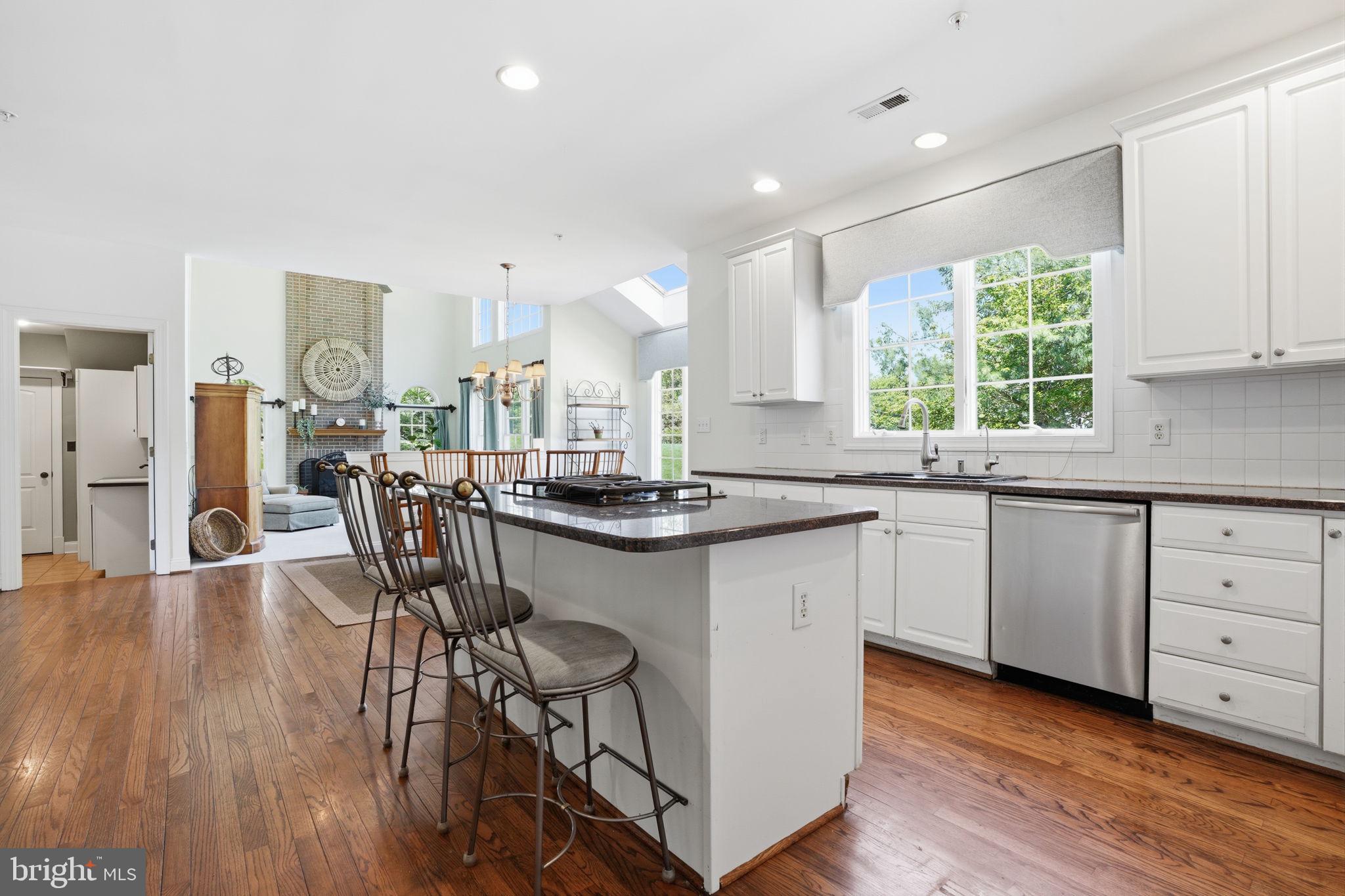 53 Alexanders Court Newtown, PA 18940 - Photo 13 of 61 a kitchen with stainless steel appliances granite countertop a stove a sink dishwasher a dining table and chairs with wooden floor