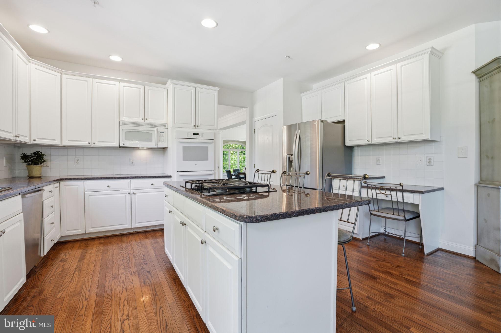 53 Alexanders Court Newtown, PA 18940 - Photo 15 of 61 a kitchen with stainless steel appliances granite countertop a stove top oven a sink dishwasher and a refrigerator with wooden floor