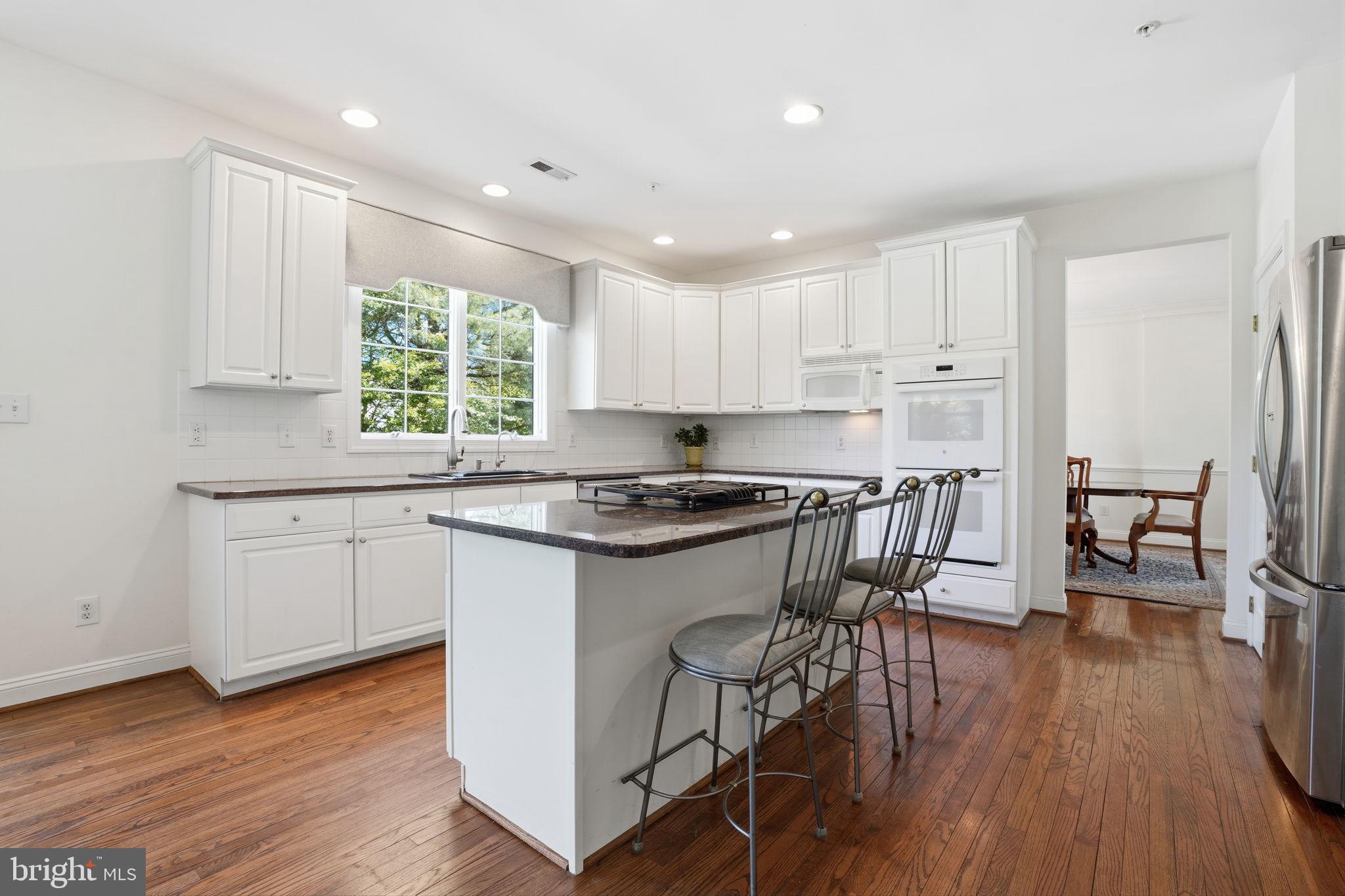 53 Alexanders Court Newtown, PA 18940 - Photo 16 of 61 a kitchen with granite countertop white cabinets wooden floor and a window