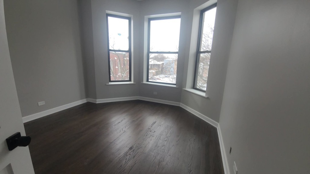 6443 South Peoria Street, Unit 1 Chicago, IL 60621 - Photo 11 of 13 an empty room with wooden floor and windows