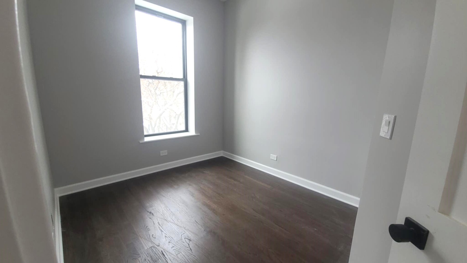 6443 South Peoria Street, Unit 1 Chicago, IL 60621 - Photo 13 of 13 an empty room with wooden floor and windows