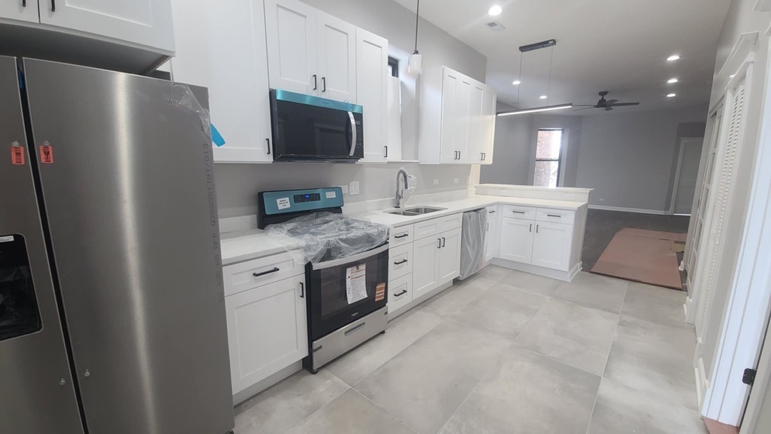 6443 South Peoria Street, Unit 1 Chicago, IL 60621 - Photo 2 of 13 a kitchen with stainless steel appliances a refrigerator sink and microwave