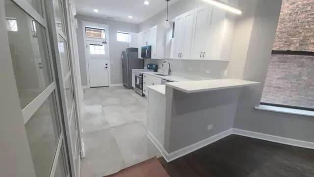 a view of hallway with window and wooden floor