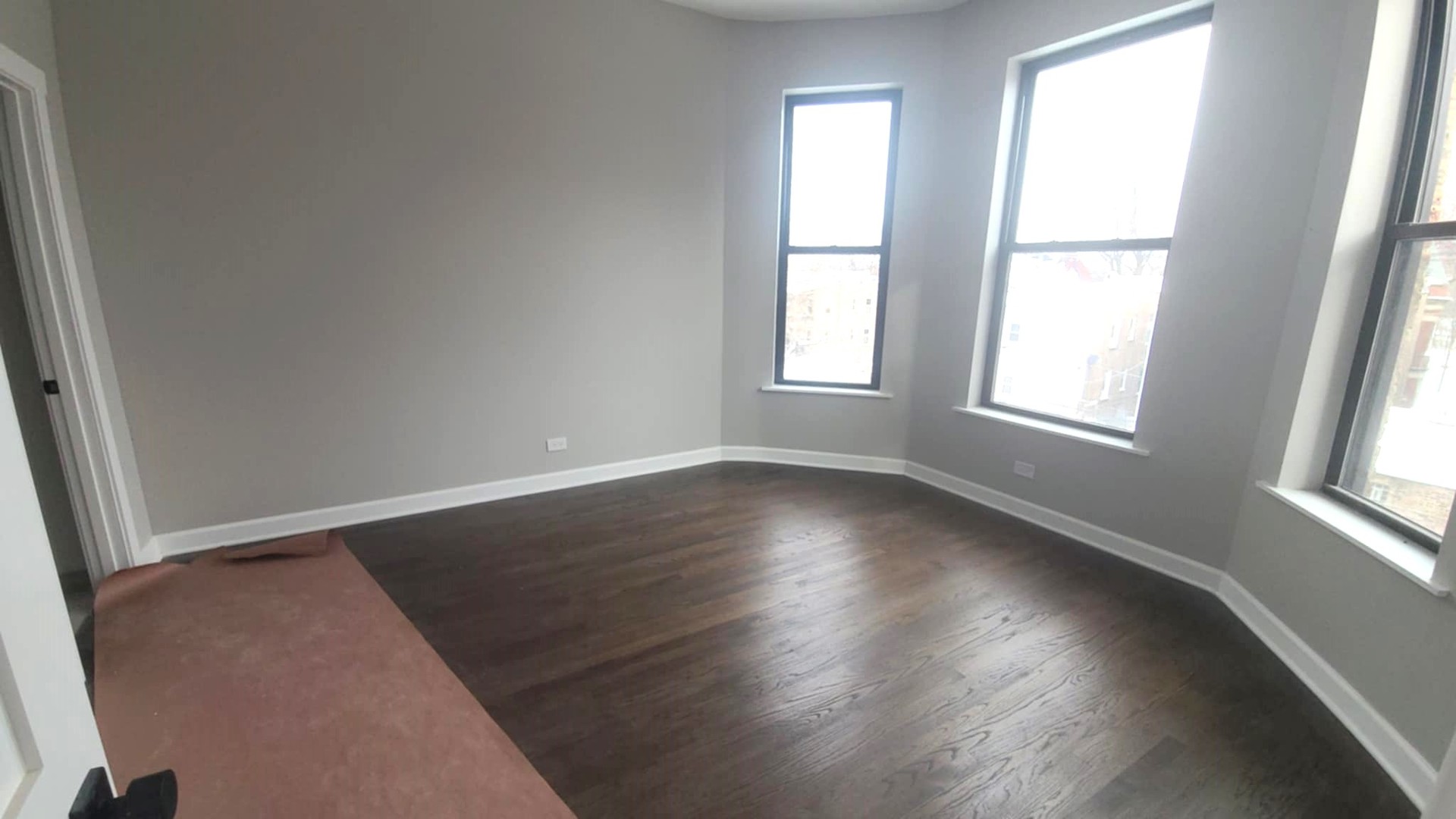 6443 South Peoria Street, Unit 1 Chicago, IL 60621 - Photo 7 of 13 an empty room with wooden floor and windows