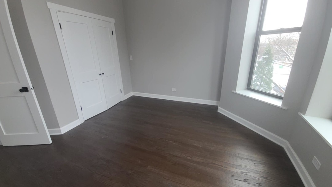 6443 South Peoria Street, Unit 1 Chicago, IL 60621 - Photo 9 of 13 an empty room with wooden floor and windows