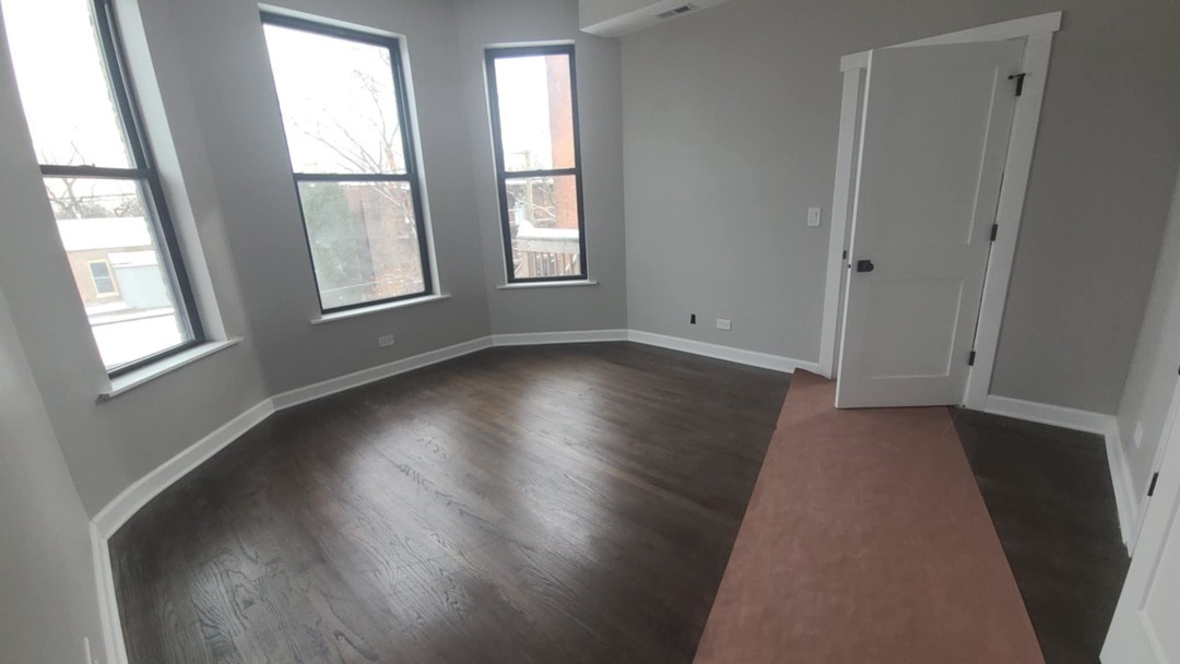6443 South Peoria Street, Unit 1 Chicago, IL 60621 - Photo 10 of 13 a view of an empty room with wooden floor and a window