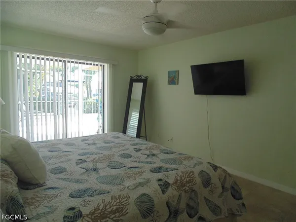 a bedroom with a bed a flat screen tv and a large window
