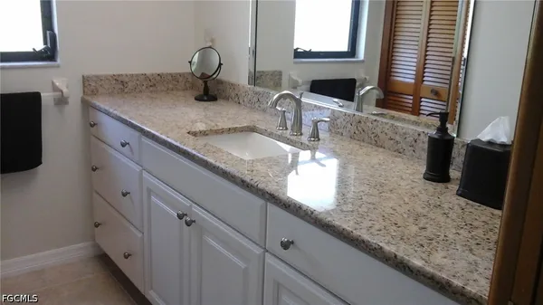 a kitchen with granite countertop a sink and a wooden floor