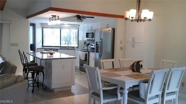 a dining room with furniture a chandelier and window