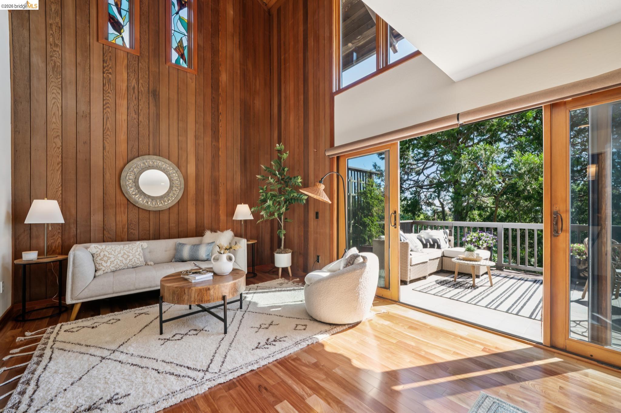 1183 Keeler Avenue Berkeley, CA 94708 - Photo 11 of 53 Living area featuring a high ceiling, wood finished floors, and wood walls