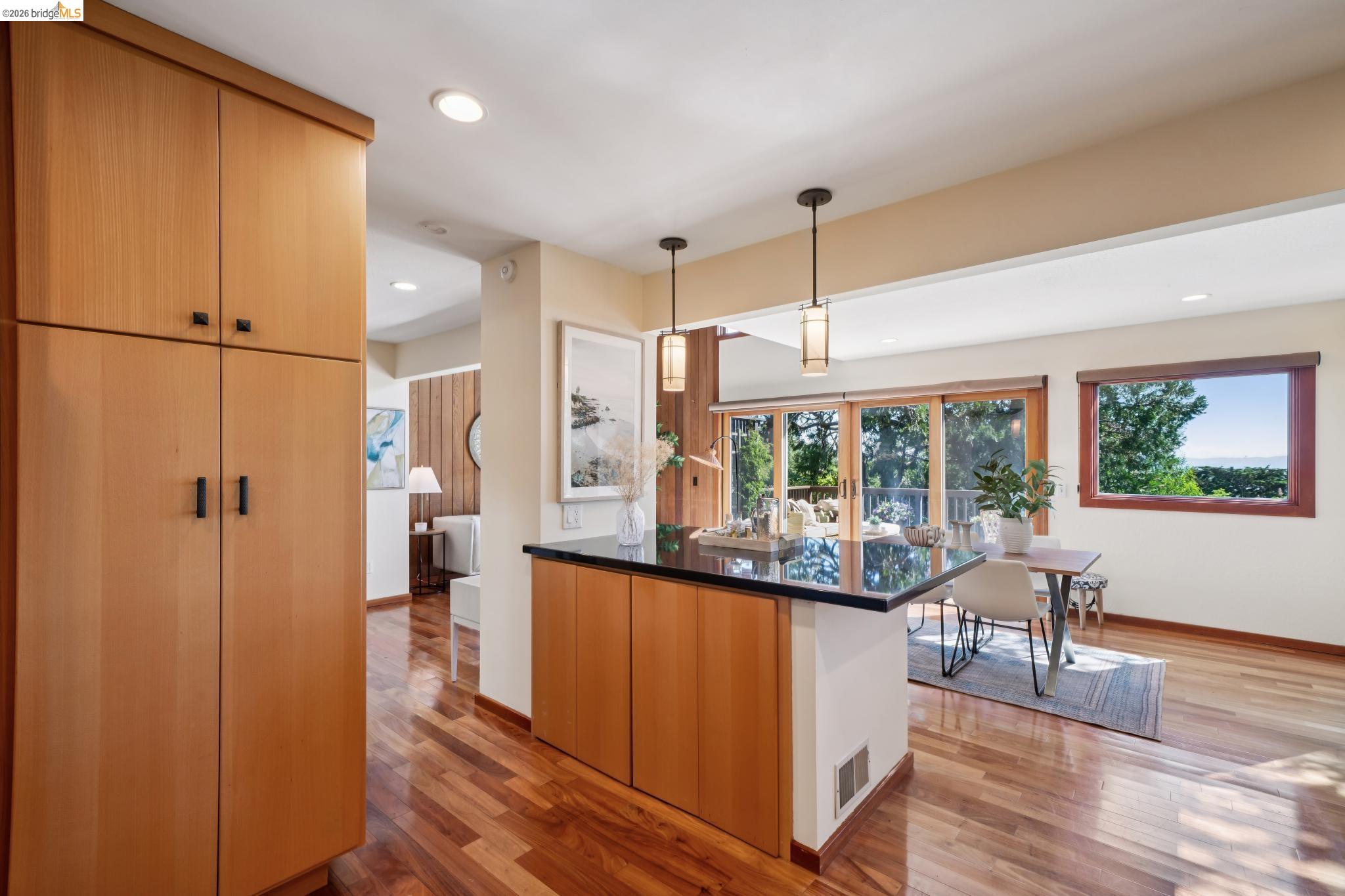 1183 Keeler Avenue Berkeley, CA 94708 - Photo 26 of 53 Kitchen featuring light wood-style floors, light wood finish cabinets, hanging light fixtures, modern cabinets, and a kitchen breakfast bar