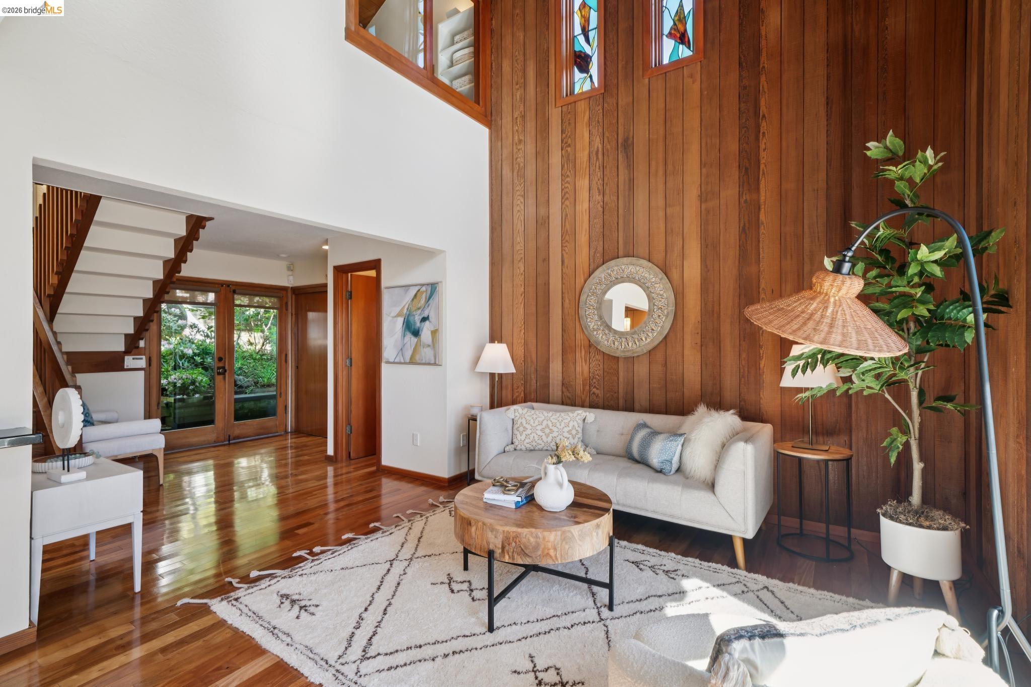 1183 Keeler Avenue Berkeley, CA 94708 - Photo 7 of 53 Living room featuring wood-type flooring, a high ceiling, french doors, and wood walls