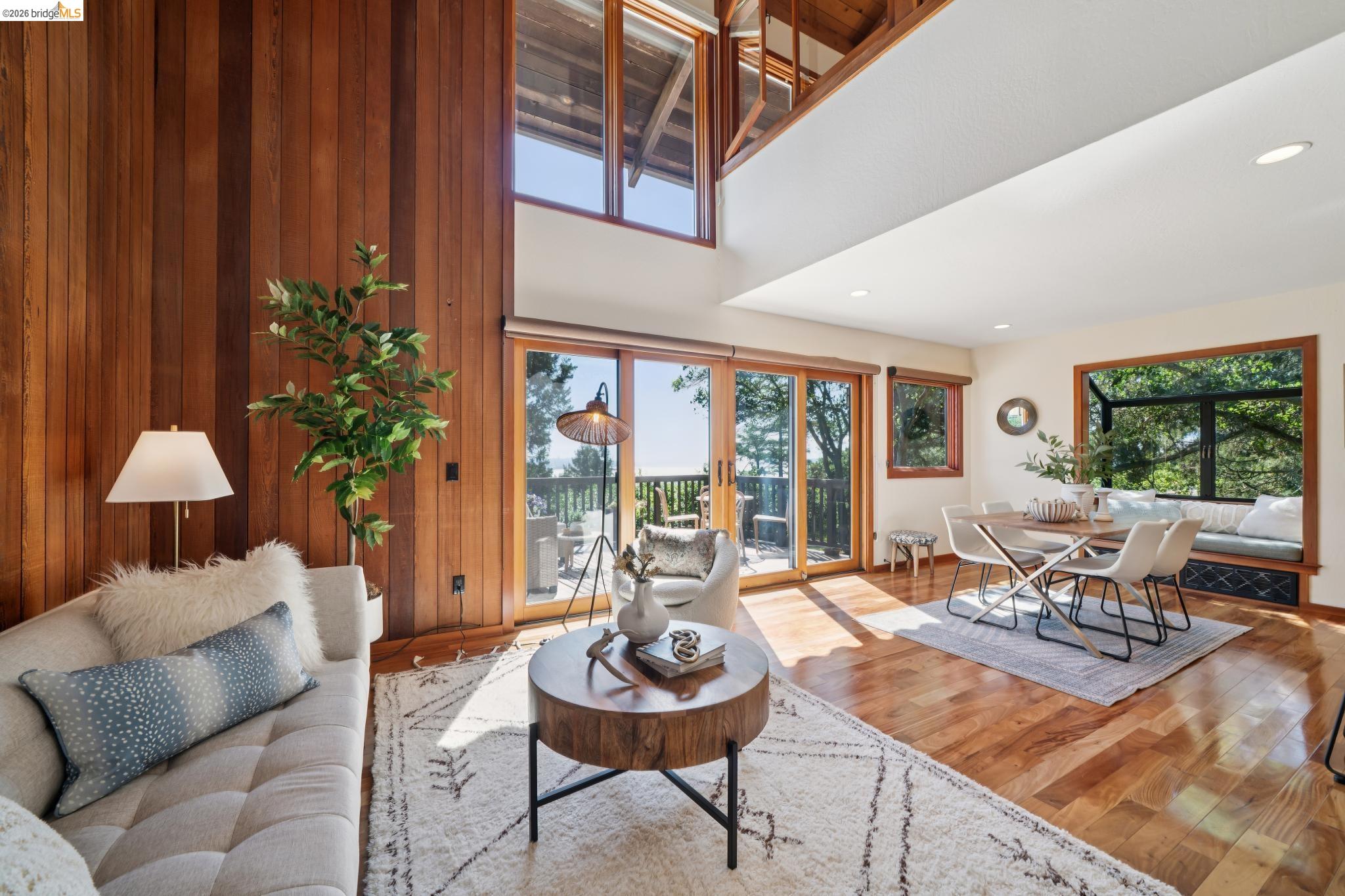 1183 Keeler Avenue Berkeley, CA 94708 - Photo 9 of 53 Living area with wood walls, wood-type flooring, and a high ceiling