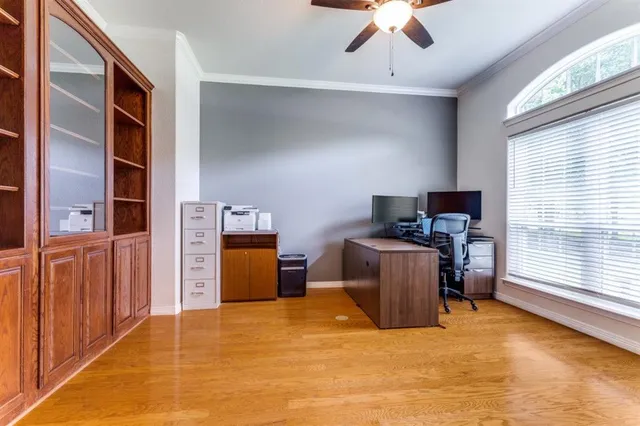 a view of a workspace with furniture and a window