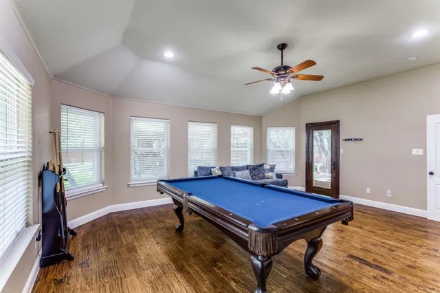 a room with pool table and windows