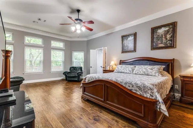 a spacious bedroom with a bed a couch and large windows