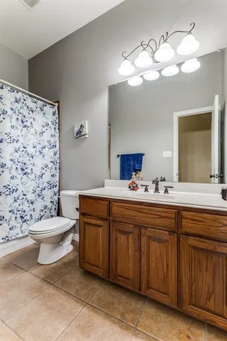 a bathroom with a sink a toilet and a mirror