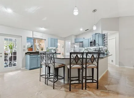 a view of a dining room with furniture and a kitchen