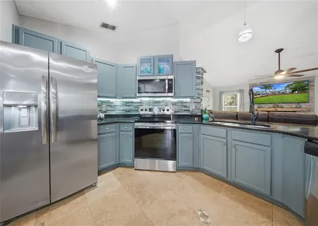 a kitchen with kitchen island a stove sink and refrigerator