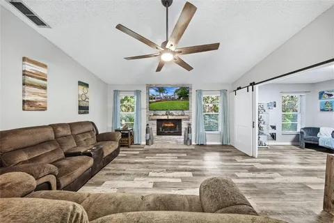 a living room with furniture large window and fireplace