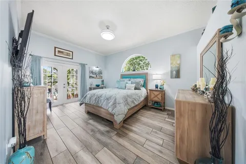 a bedroom with a bed closet and a flat tv screen on dresser