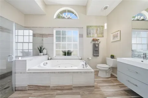 a bathroom with a bathtub a sink and a large mirror