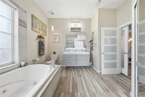 a bathroom with a bathtub double vanity sink and a mirror