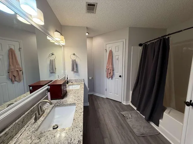 a living room with large mirror and a wooden floor