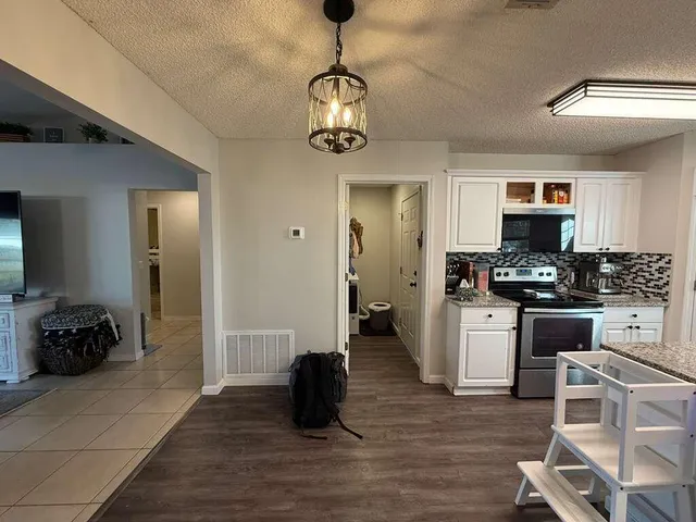 a kitchen with a refrigerator and a stove top oven