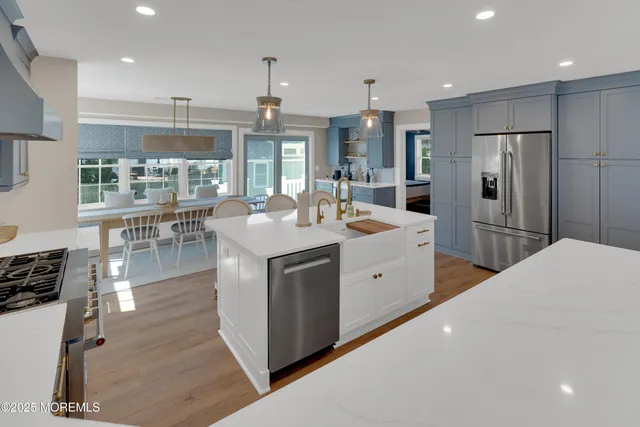 a large white kitchen with a large window and stainless steel appliances