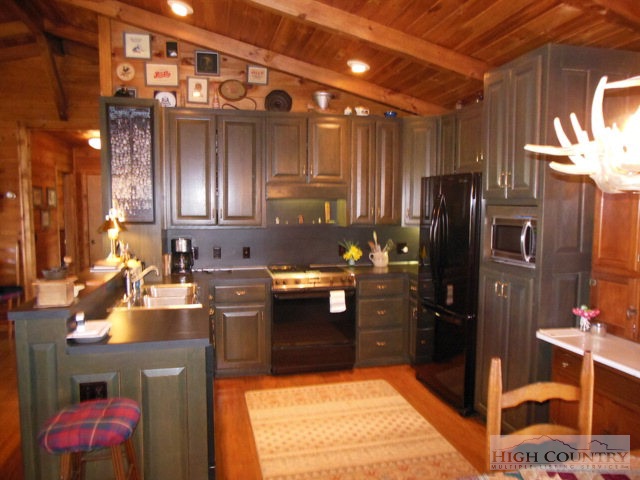 1242 Lazy Branch Road Ennice, NC 28623 - Photo 19 of 29 a kitchen with kitchen island granite countertop a refrigerator stove and sink