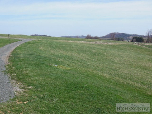 1242 Lazy Branch Road Ennice, NC 28623 - Photo 6 of 29 a view of a field with an ocean and trees in the background
